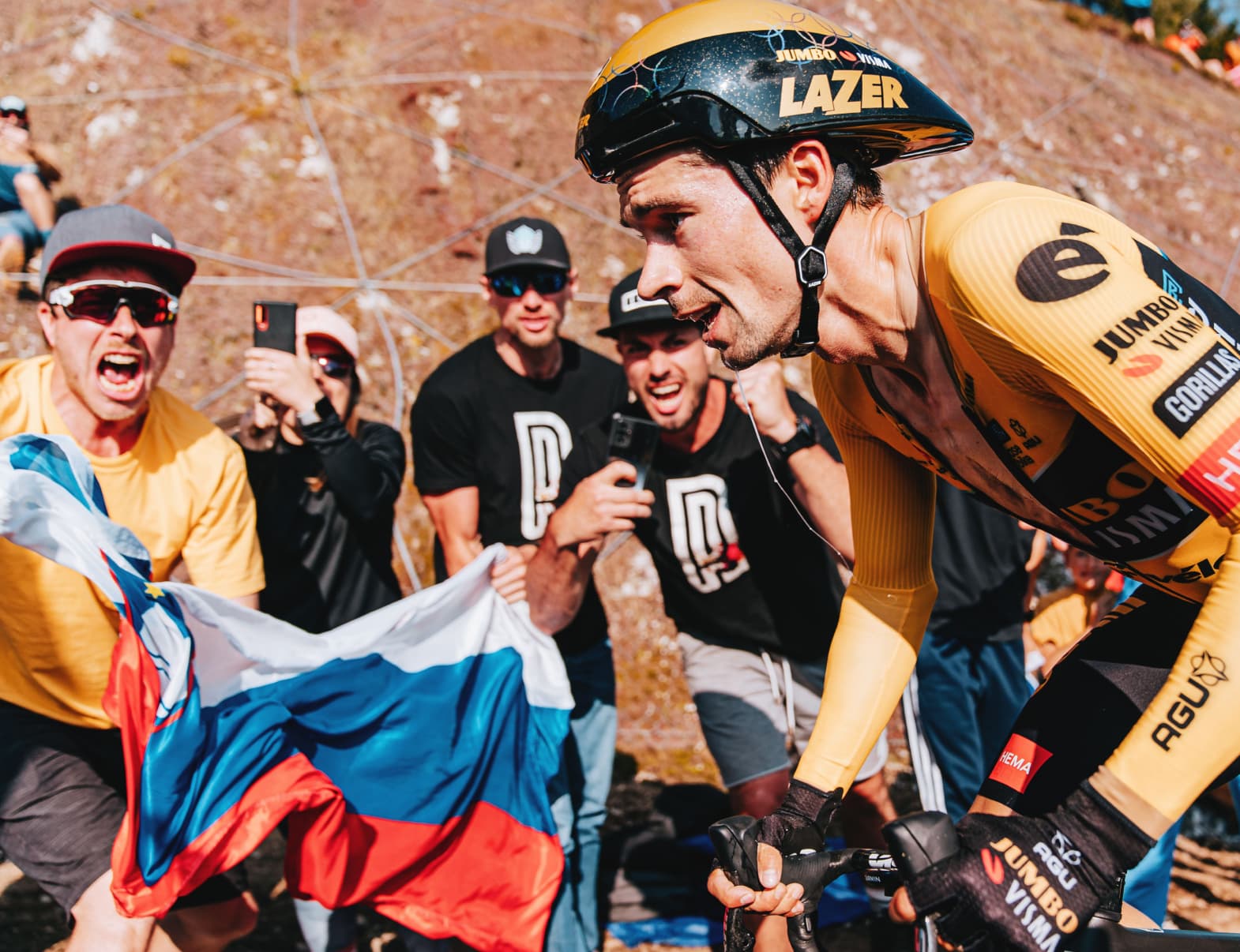 A photo of Primož Roglič out of the saddle and pedaling hard on the steepest part of the time trial course.