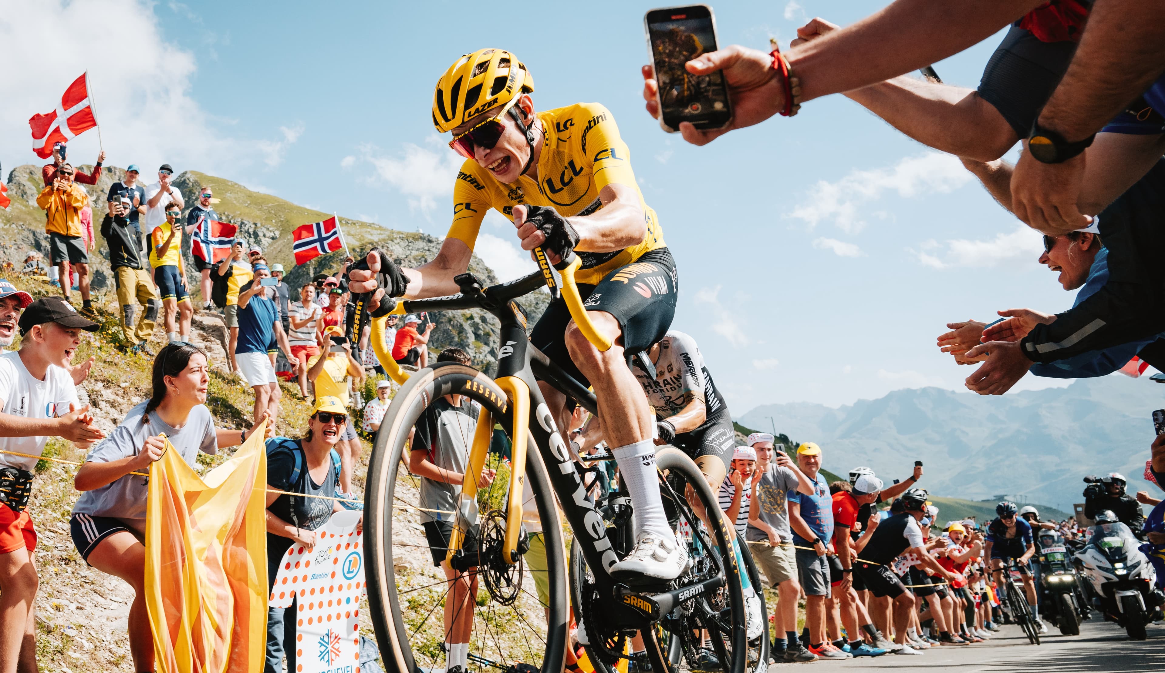 Jonas Vingegaard racing in the Tour de France wearing yellow and climbing with effort on his Cervélo R5.