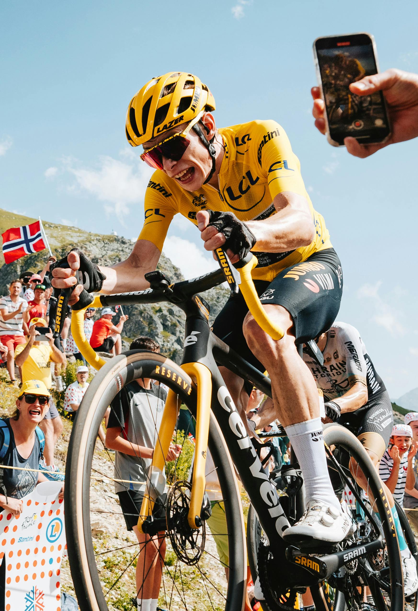 Jonas Vingegaard racing in the Tour de France wearing yellow and climbing with effort on his Cervélo R5.