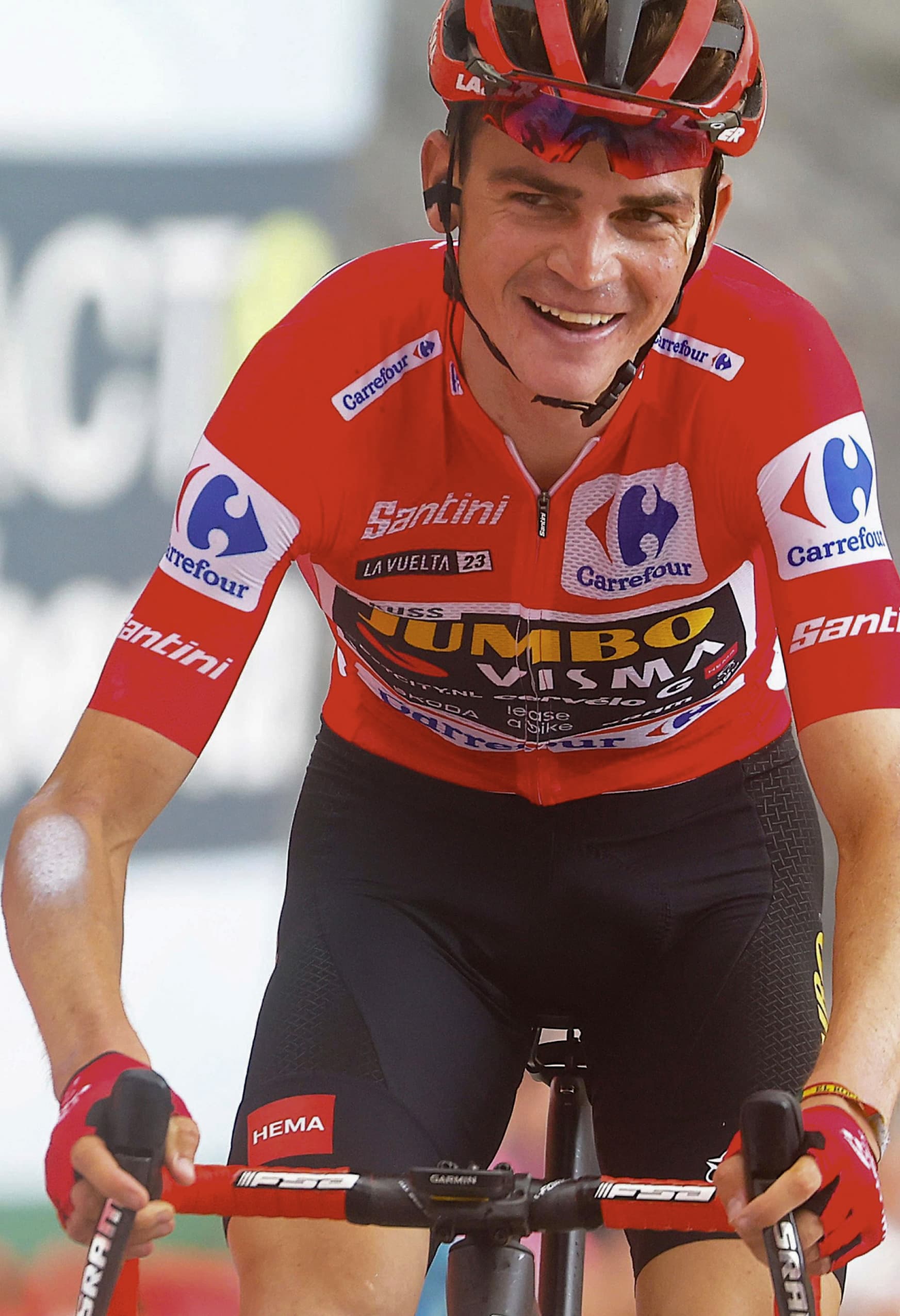 Sepp Kuss smiles while wearing the Red Jersey of the Vuelta a España.