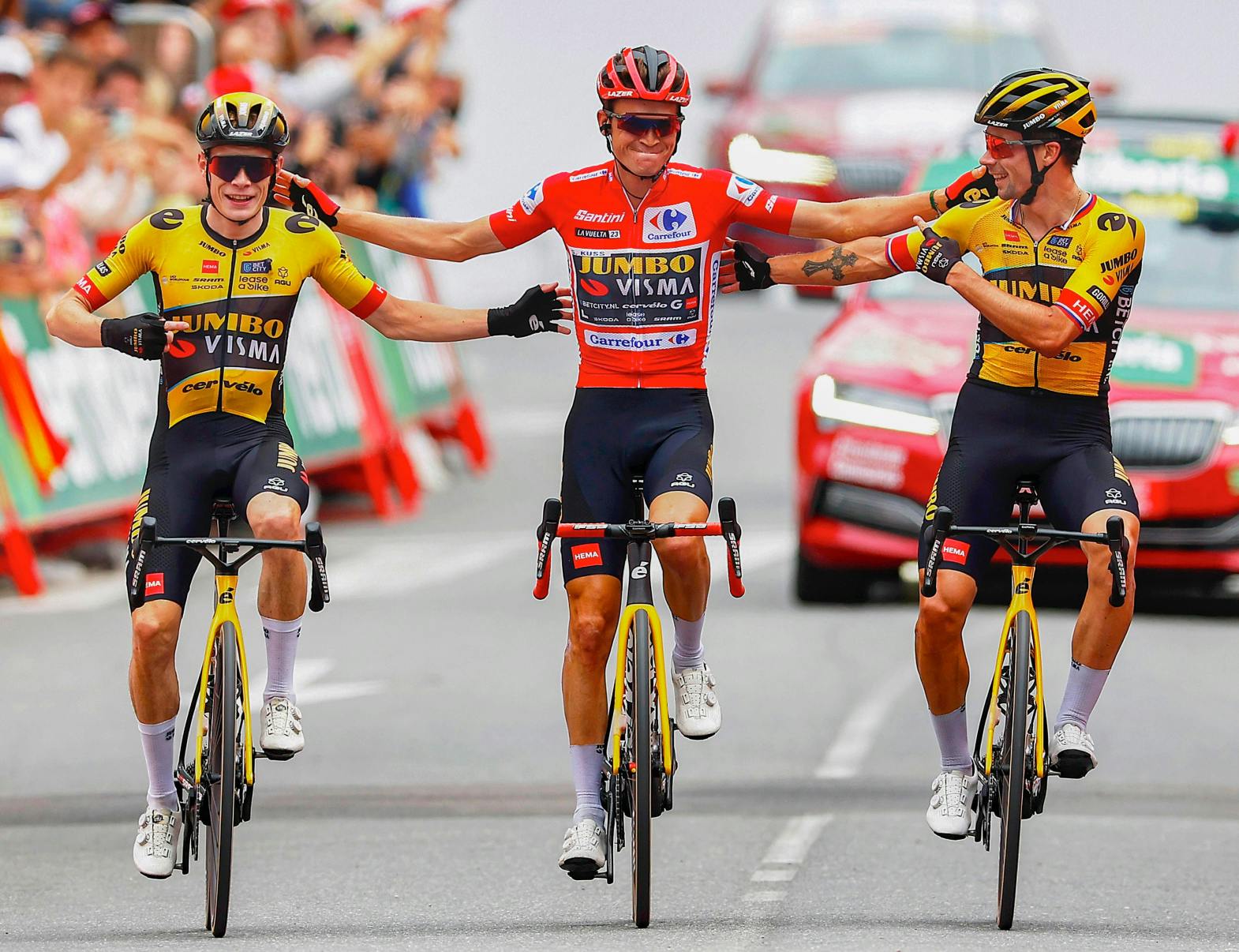 Sepp Kuss, Jonas Vingegaard, and Primož Roglič ride across the line together in celebration of Sepp’s Vuelta win.